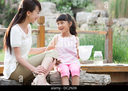 Happy Chinese mother and daughter playing in a park Stock Photo