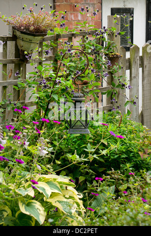 Old lantern and fence in cottage English garden, England Stock Photo