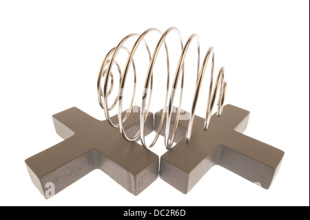 Iron wire tangled up into spiral ball resulting in a shiny chrome sphere, lying on its side on top of two gray crosses isloated