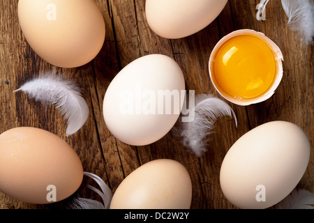 Eggs, whole and broken, on wooden background. Top view Stock Photo