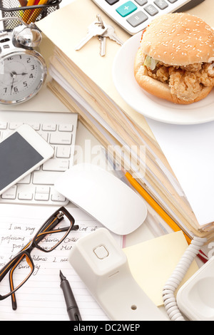 Fast food and other office items on desk Stock Photo