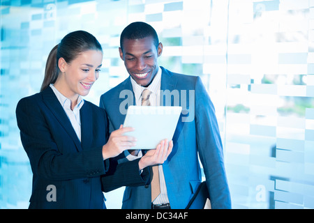 Smiling businessman and businesswoman using digital tablet Stock Photo
