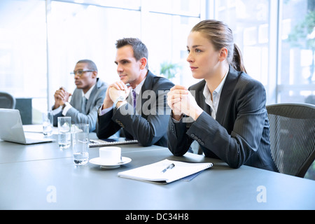 Attentive business people with hands clasped in meeting Stock Photo