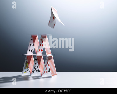 Cards jumping from house of cards Stock Photo