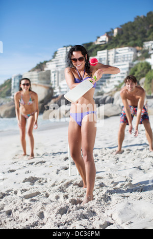 Portrait of woman playing paddle ball on beach Stock Photo