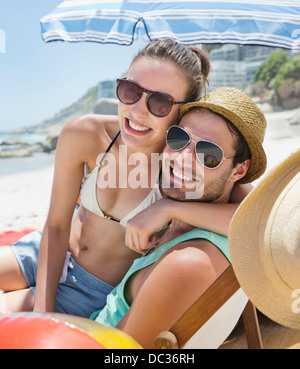 Portrait of smiling couple wearing sunglasses on beach Stock Photo