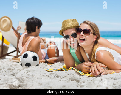 Portrait of smiling couple laying on beach Stock Photo