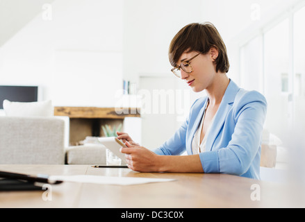 Woman using digital tablet at table Stock Photo