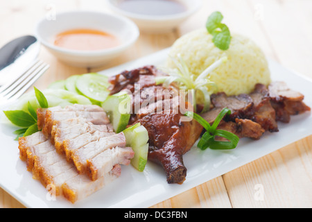 Roasted duck, roasted pork crispy siu yuk and Charsiu Chinese style, served with steamed rice on dining table. Malaysia cuisine. Stock Photo