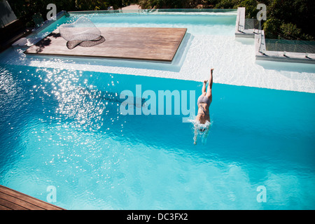 Woman diving in luxury swimming pool Stock Photo