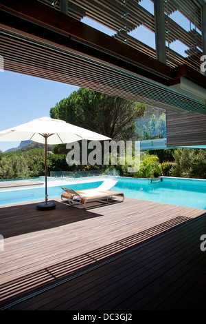 Swimming pool, lounge chair, umbrella Stock Photo