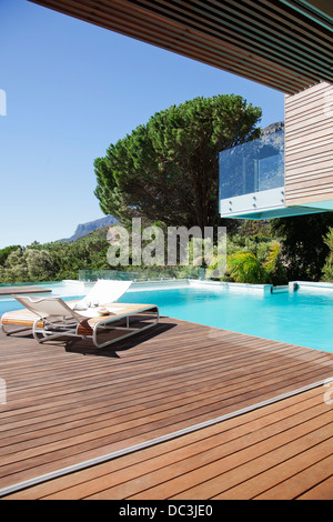 Luxury swimming pool and lounge chairs on deck Stock Photo