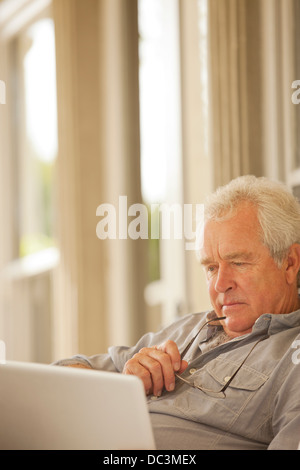 Serious senior man using laptop Stock Photo