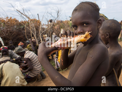 Dassanech Tribe Warriors Sharing Cow Meat During A Ceremony, Omorate, Omo Valley, Ethiopia Stock Photo