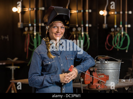 Female welder in industrial background. Stock Photo
