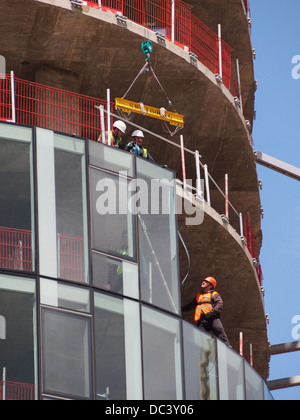 Construction workers installing windows on a building Stock Photo