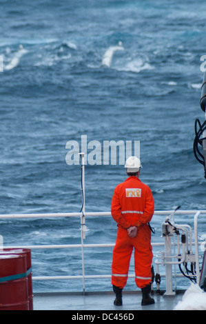 Crew member gun Mechanic at seismic Vessel MV Ocean Europe Gun boat looking for towed air guns at ocean Stock Photo