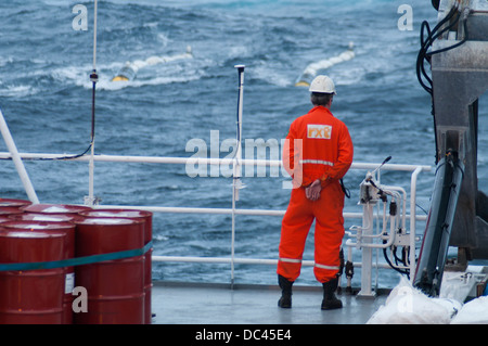 Crew member gun Mechanic at seismic Vessel MV Ocean Europe Gun boat looking for towed air guns at ocean Stock Photo