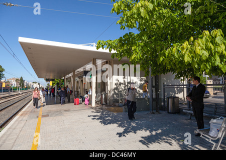 Passengers waiting on Salou Railway Station in the sunshine Stock Photo