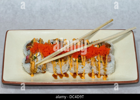 Authentic Japanese food photographed with a contemporary American flair. Salmon rolls are displayed with red caviar .