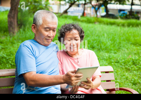 happy seniors couple with tablet pc in the park Stock Photo