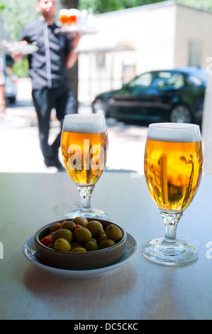 Spanish aperitif: two glasses of beer with olives in a summer terrace. Madrid, Spain. Stock Photo