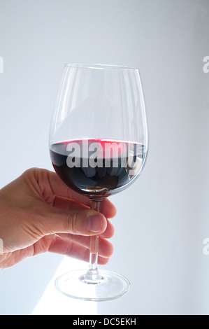 Man's hand holding a glass of red wine. Close view. Stock Photo