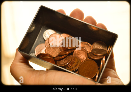Hand holding a black box of euro coins. Stock Photo