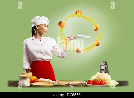 Asian female chef slicing oranges Stock Photo