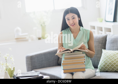 Woman with stack of books at home Stock Photo