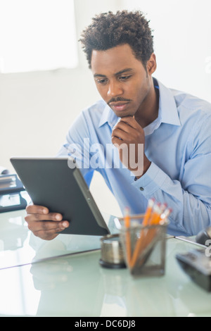 Businessman using tablet PC in office Stock Photo