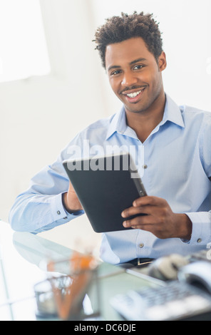 Businessman using tablet PC in office Stock Photo