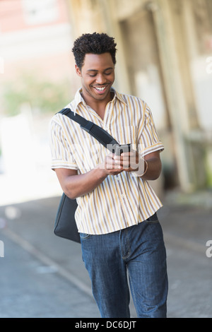 Man walking on street and text messaging Stock Photo