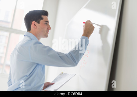 Businessman writing on whiteboard Stock Photo