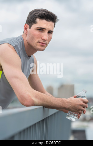 Athlete leaning against railing Stock Photo