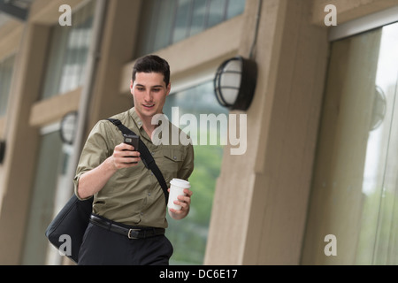 Man walking on street and text messaging Stock Photo