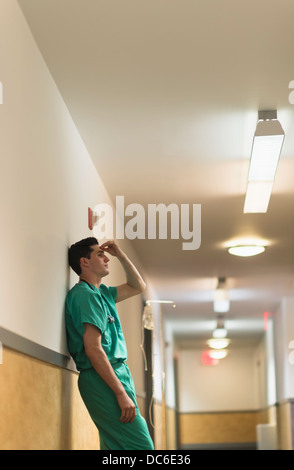 Tired doctor standing in hallway Stock Photo