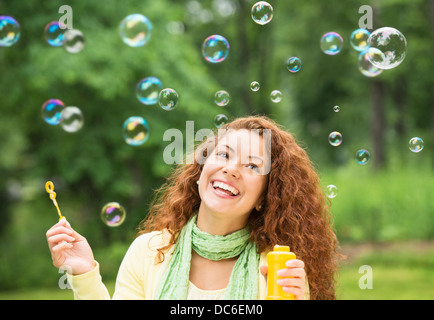 Young woman blowing bubbles in park Stock Photo