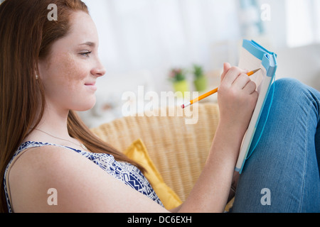 Contemplative teenage girl in underwear sitting in bed Stock Photo