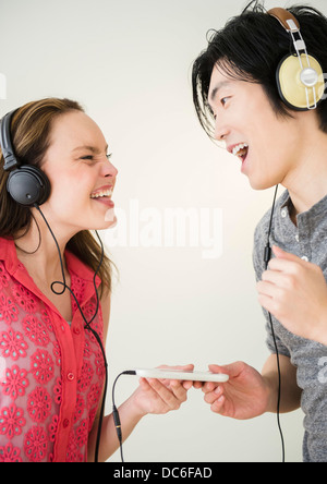 Portrait of young woman and man listening to music on MP3 player Stock Photo