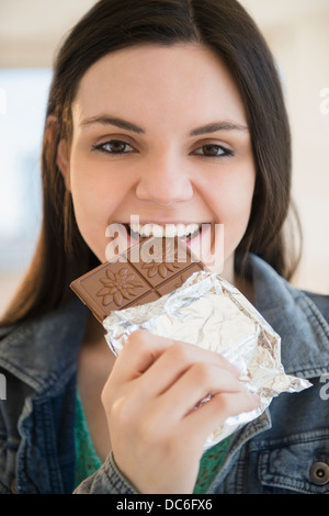 Young woman eating bar of chocolate Stock Photo