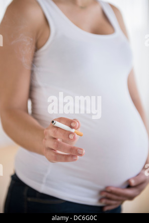 Mid section of pregnant woman holding cigarrete Stock Photo
