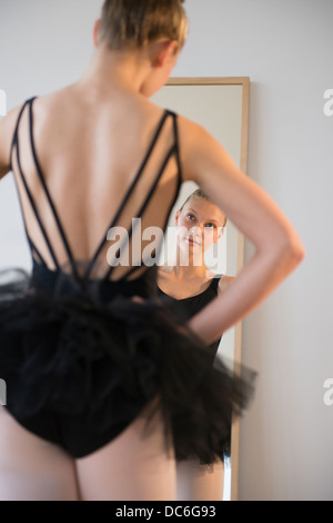 Rear view of teenage (16-17) ballerina looking into mirror Stock Photo