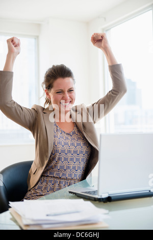 Portrait of cheering woman in office Stock Photo