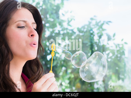 Portrait of woman blowing bubbles Stock Photo