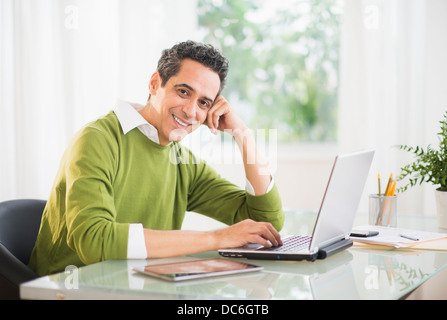Portrait of man working on laptop at home Stock Photo