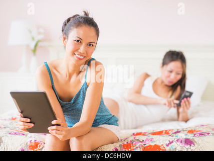 Two women using digital tablet and mobile phone Stock Photo