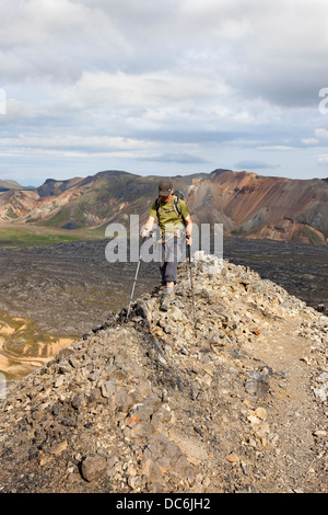 Hiker on the Mountain of Blahnukur Looking Towards the Colourful Brennisteinsalda Volcano Near Landmannalaugar Iceland Stock Photo