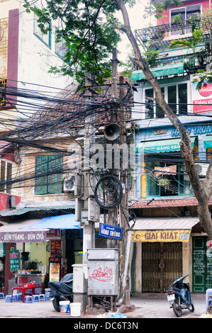 Hanoi, Vietnam - typical tangle of electrical and telephone cables above a street in the Old Quarter Stock Photo