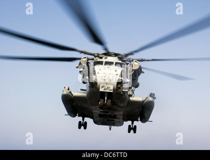 A US Marine Corps CH-53E Super Stallion helicopter prepares to land on the flight deck of the USS San Antonio July 19, 2013 in the Arabian Sea. Stock Photo